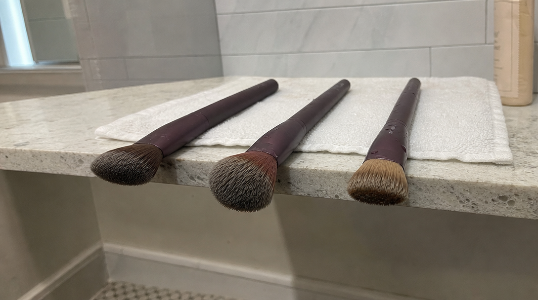 jak suszyć pędzle do makijażu — pędzle leżące poziomo z włosiem poza krawędzią blatu